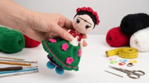 Muñeca Frida Kahlo amigurumi tejida a crochet con flores coloridas en la cabeza, ideal como decoración artesanal