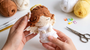 Anjo de Natal amigurumi branco e dourado com detalhes delicados, usado como enfeite artesanal elegante de árvore.