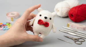 Bonitinho urso amigurumi branco com gravata vermelha de crochê para decoração de quarto de bebê ou presente artesanal exclusivo.