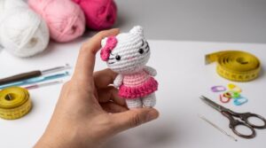 Hello Kitty amigurumi em crochê branco e rosa, detalhe de laço bordado, pronta para decoração ou presente artesanal.
