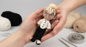 Patrón de amigurumi de cantante, muñeca con hilo de algodón en blanco y negro, cabello peluche amarillo para decoración musical artesanal.