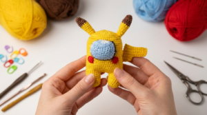 Pikachu Among Us amigurumi, muñeco de ganchillo en color amarillo y azul con textura de algodón, ideal para decoración temática de videojuegos.