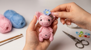 Porquito amigurumi tejido en algodón de color rosado suave, ideal como llavero artesanal para decorar bolsos o regalar a seres queridos.