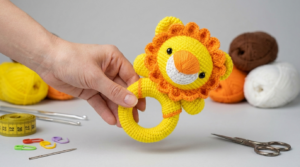 Chocalho de Leão amigurumi em tom caramelo feito em crochê artesanal ideal como brinquedo sensorial para bebês recém nascidos.