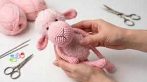 Ovelha de crochê branca com fio macio e detalhes pretos em amigurumi, perfeita para decoração infantil ou presente.