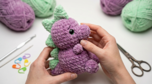 Trex dinossauro amigurumi verde feito em crochê com acabamento delicado para decoração de quarto infantil artesanal.